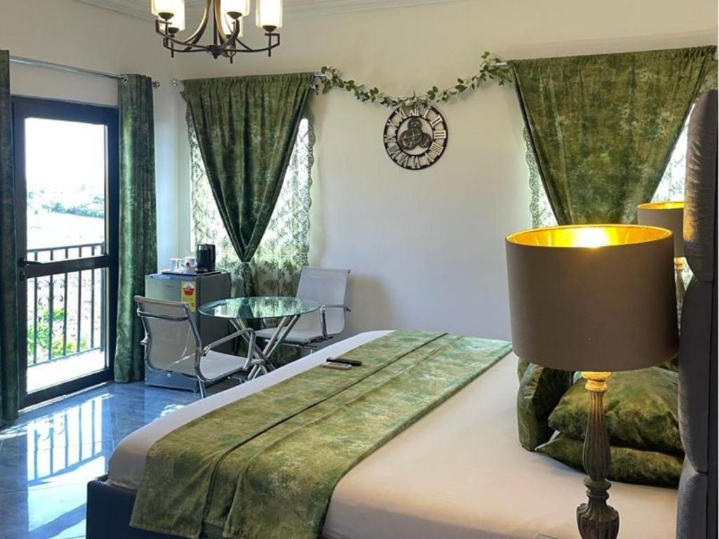 a bedroom with a bed with a lamp and a table at Perriman Hotel in Kokrobite