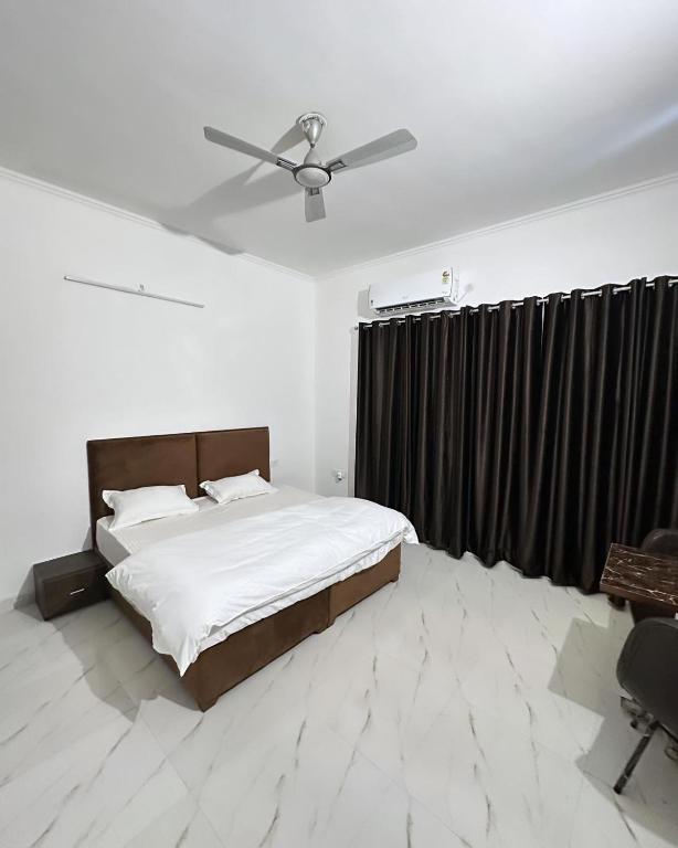 a bedroom with a bed and a ceiling fan at Cds residency in Greater Noida
