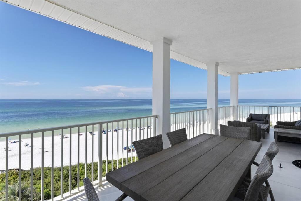 - une terrasse couverte avec une table et des chaises en bois et la plage dans l'établissement Grand Playa Unit 402 Gulf Front Condo, à Santa Rosa Beach