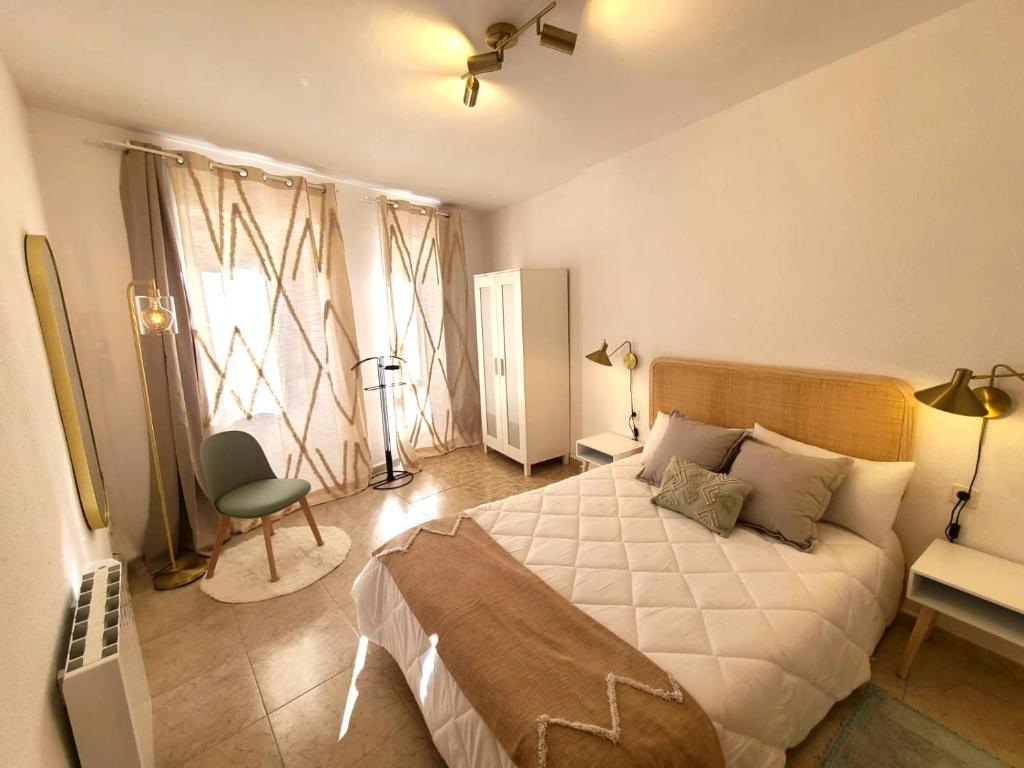 a bedroom with a bed and a desk and a chair at Acogedor apartamento para dos en el centro in Huesca