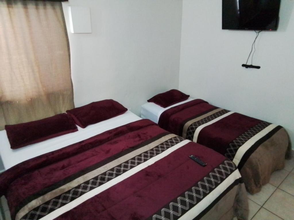 dwa łóżka siedzące obok siebie w pokoju w obiekcie Estancia la Ocho w mieście Tijuana