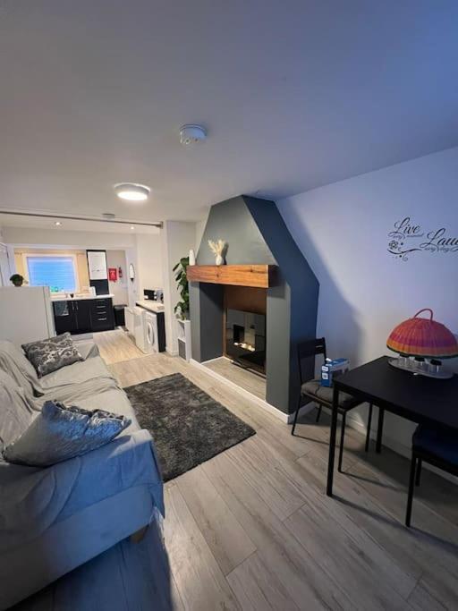 een woonkamer met een bed en een tafel. bij Haven - Beautiful 3 Bedroom house in Ballynahinch