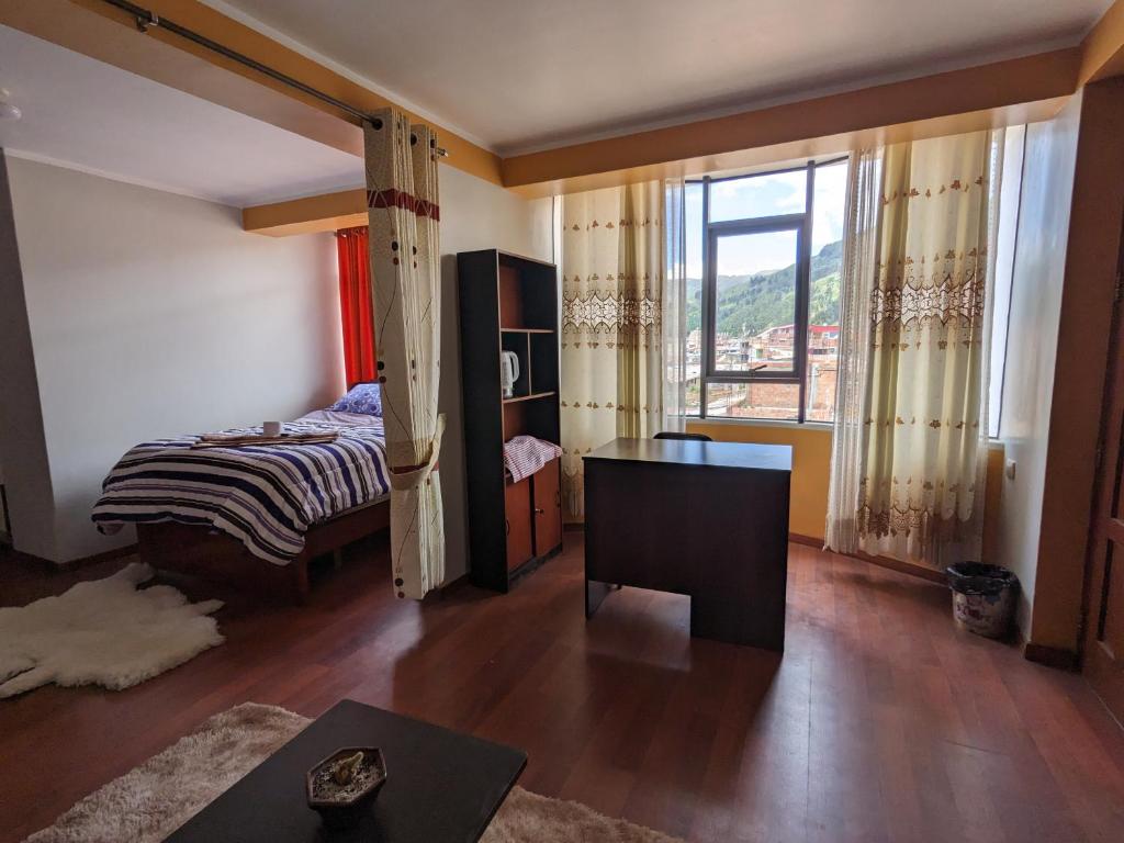 - une chambre avec un lit, un bureau et une fenêtre dans l'établissement MINIDEPARTAMENTO SICUANI, à Sicuani