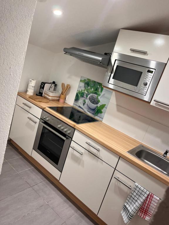 a kitchen with a stove and a microwave at Tannenzapfen in Auffach