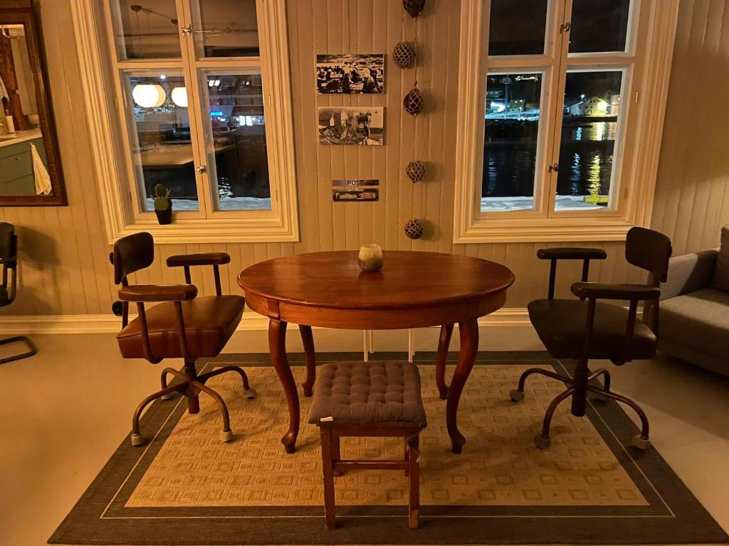 una mesa de madera y sillas en la sala de estar. en 1. etg i Dampskipsbrygga, Lødingen havn en Lødingen