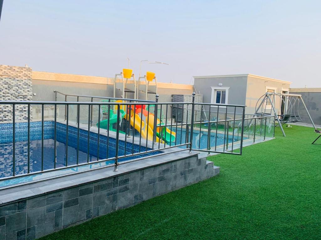 una piscina con tobogán y un parque infantil en استراحة زهرة الاماكن 2, en Yeda