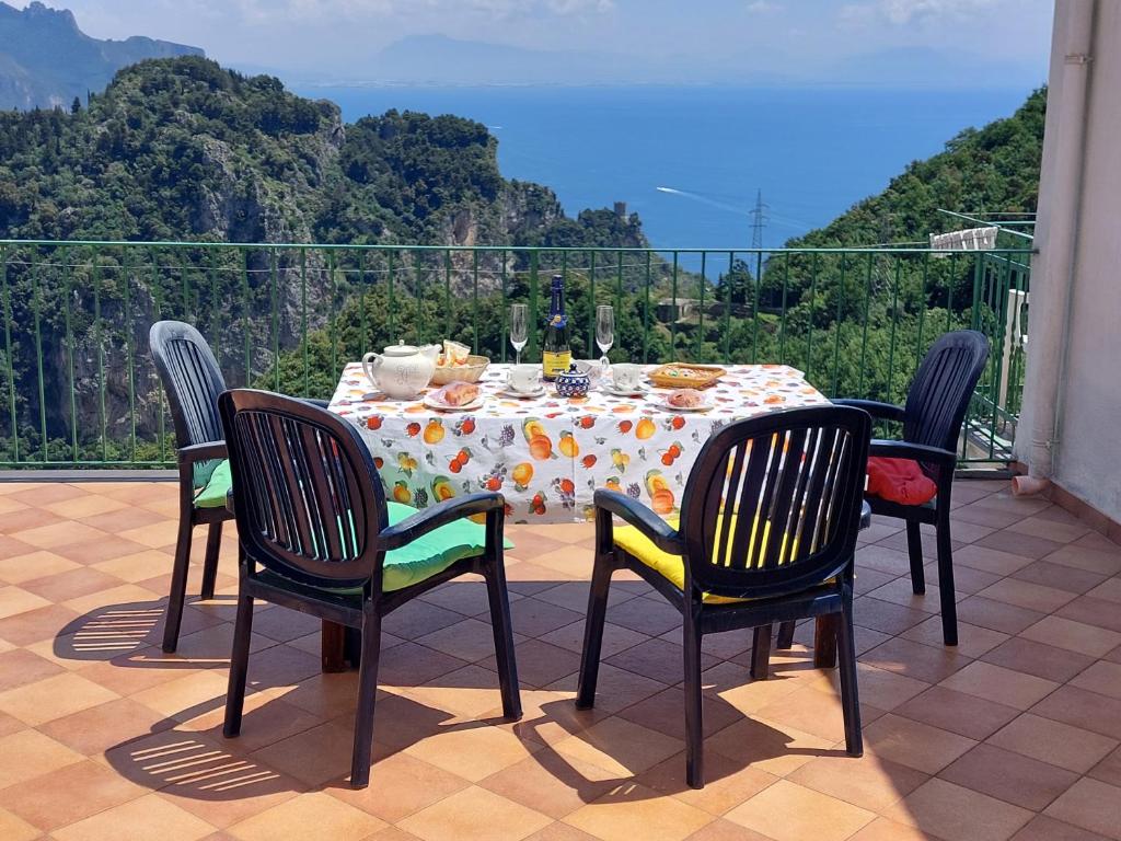 a table with chairs and a table with food on it at JANET HOUSE in Amalfi