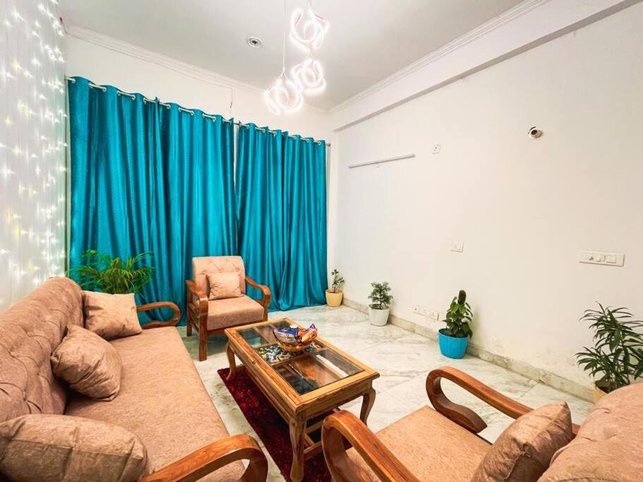 een woonkamer met een bank en een tafel bij Love Lounge - Luxury 3BHK Villa in Greater Noida in Noida