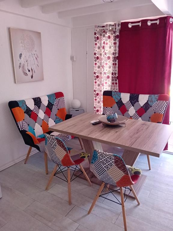 - un salon avec une table en bois et 2 chaises dans l'établissement maison de vacances tout confort, au Cap d'Agde