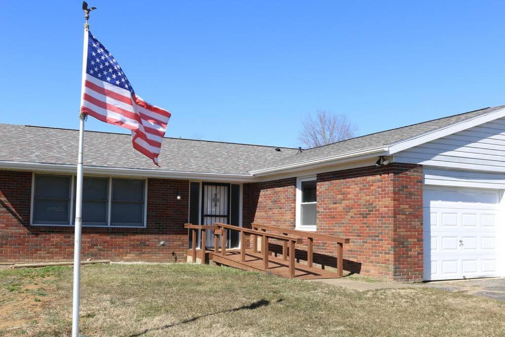 a american flag in front of a brick house at Rt. 682 Athens, 3 Queen bedrooms, 2 baths, Wi-Fi in Athens