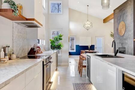 a large kitchen with white counter tops and appliances at Château Céleste - Villa with pool, hot tub, fire pit in Cantley