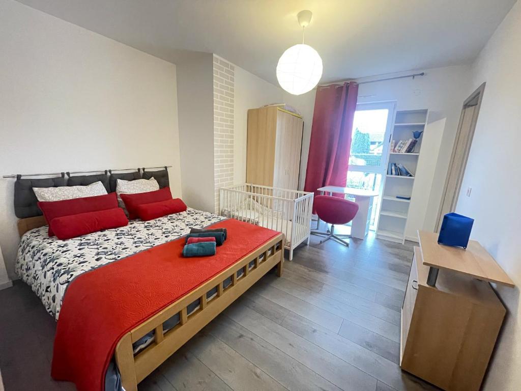 ein Schlafzimmer mit einem großen Bett mit roten Kissen in der Unterkunft nuovo appartamento saint louis 68300 tra francia e svizzera in Saint-Louis