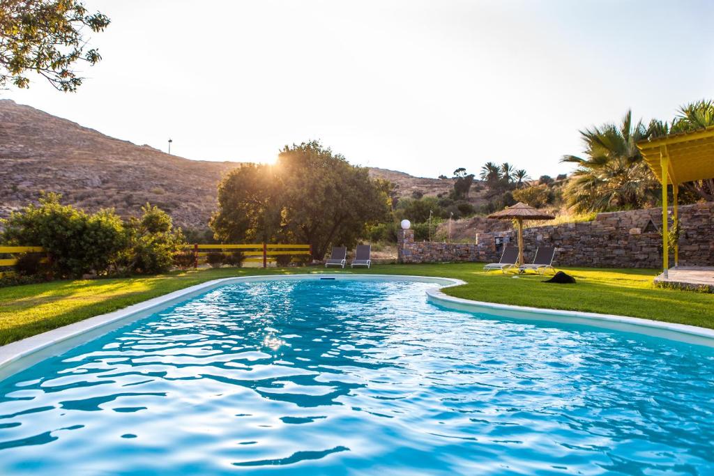een zwembad in een tuin met een heuvel op de achtergrond bij "Palatiana Agriturismo-Philoxenia Cottages", Private Nature Retreats in Galini