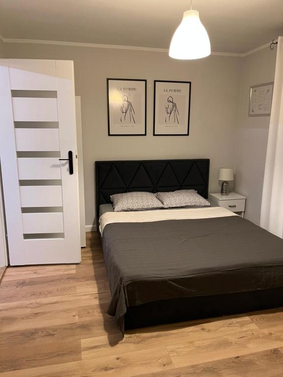 ein Schlafzimmer mit einem Bett und zwei Bildern an der Wand in der Unterkunft Pokoje u Asi in Augustów
