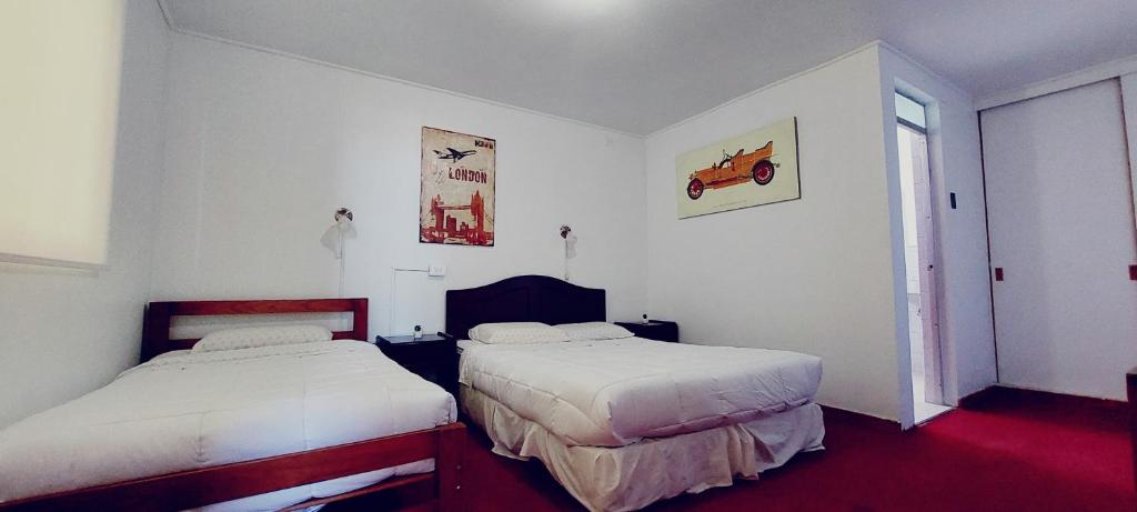 a bedroom with two beds and a window at HOTEL 507 INN in Mejillones