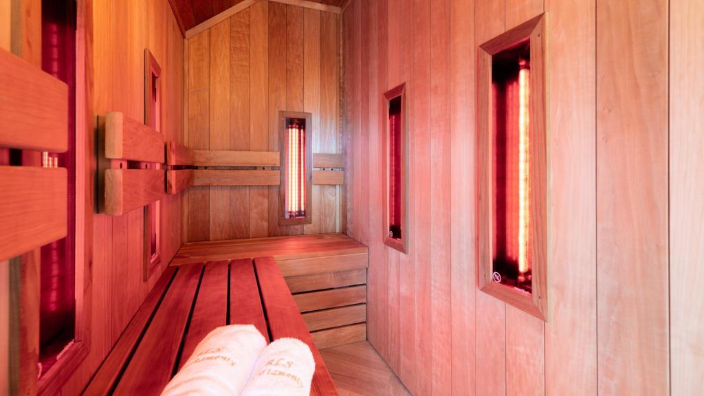 un banco de madera en una habitación con 2 ventanas en Komfortowy Apartament LOTOS z sauną i widokiem na Śnieżkę, en Karpacz