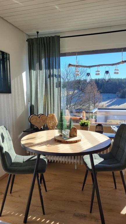 a dining room with a table and chairs and a window at FeWo Gretel in Schönwald