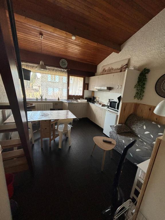 a kitchen with a table and a dining room at Duplex rénové dans résidence privé proche de toutes commodités place de parking inclu in La Bourboule