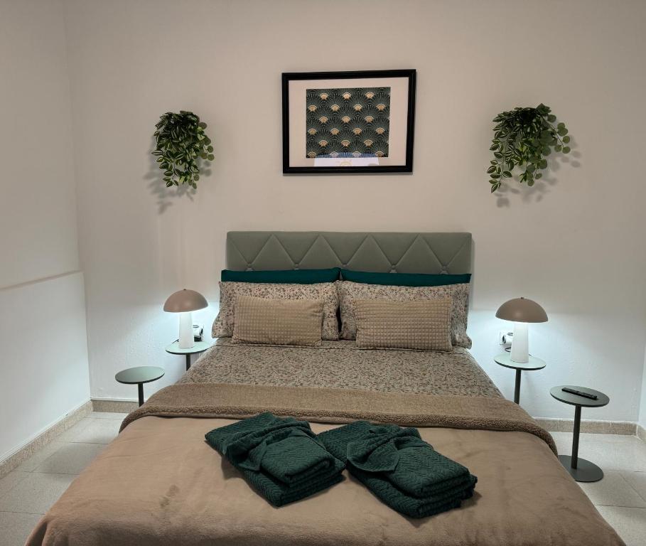a bedroom with a bed with two green towels on it at DREAM MAJUELOS in Las Lagunas