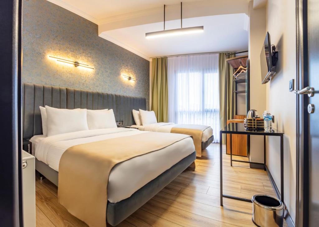 um quarto de hotel com duas camas e uma televisão em Lenora Airport Hotel em Arnavutköy