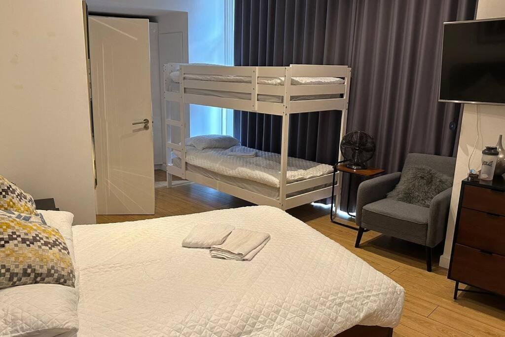 a bedroom with two bunk beds and a chair at Sleep 6 Piccadilly Grand in London VR5 in London