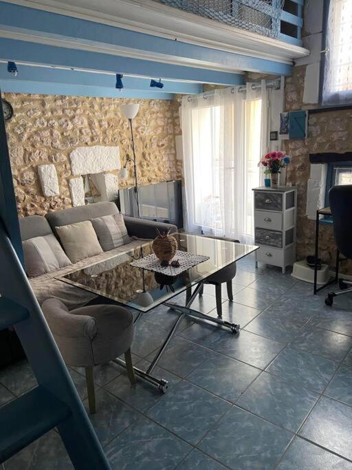 un salon avec un canapé et une table en verre dans l'établissement Location Mortagne -Sur Gironde, à Mortagne-sur-Gironde