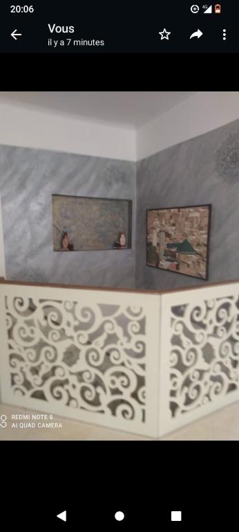a picture of a room with two pictures on the wall at Duplex mignant in Fez