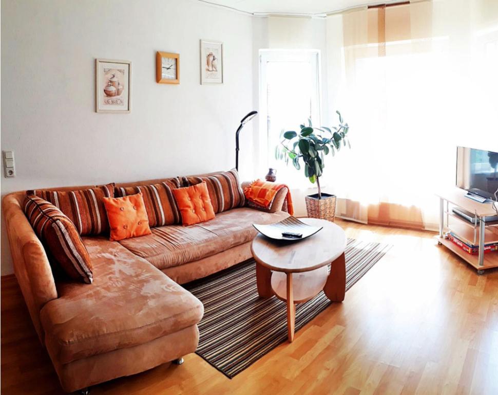 sala de estar con sofá marrón y mesa en Ferienwohnung Maria Miller, en Hemfurth-Edersee