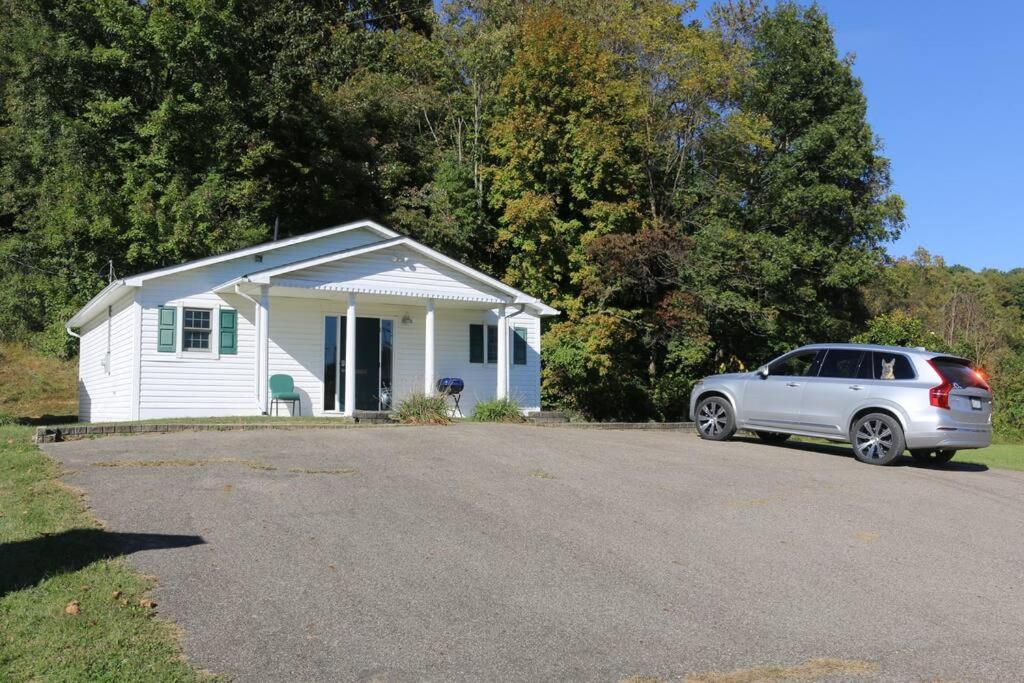 um carro branco estacionado em frente a uma pequena casa em Small House, 2 queen bedrooms, 1 bath, on route 33 em Nelsonville