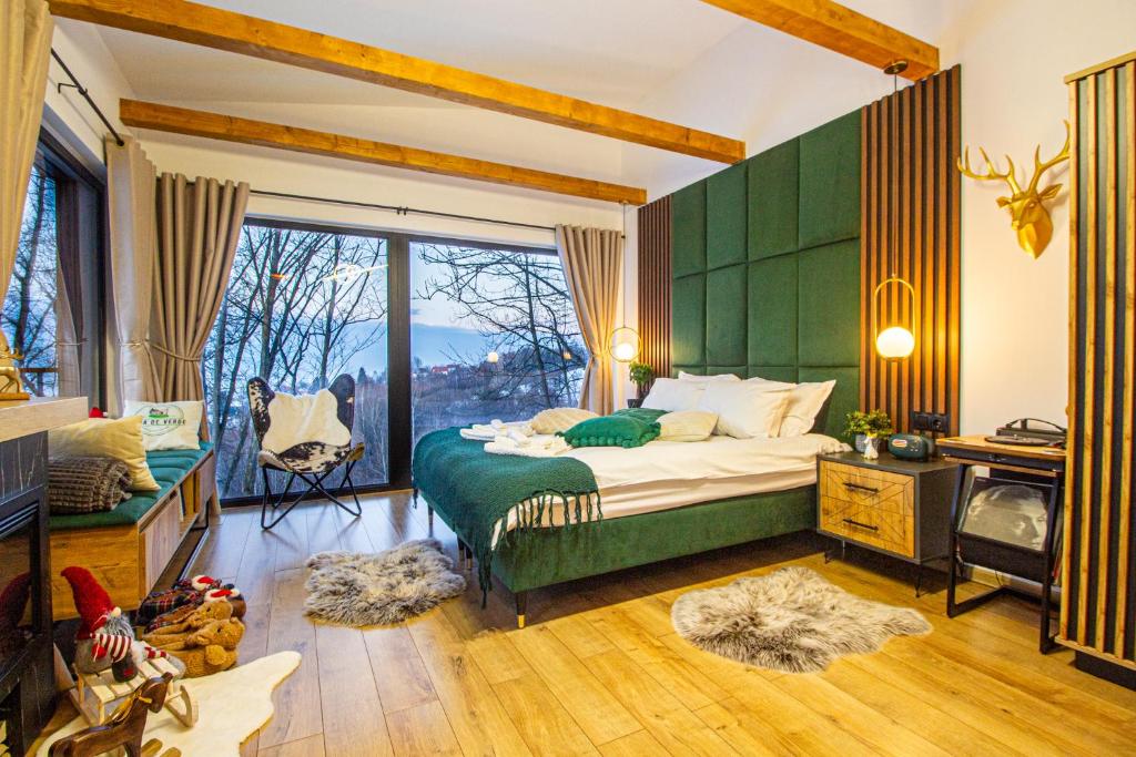 a bedroom with a bed with a green wall at Doza de Verde Chalet Bran in Sohodol