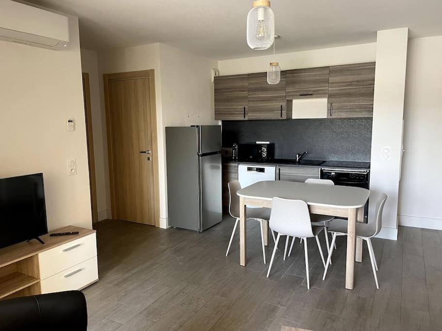 une cuisine avec une table et des chaises dans une pièce dans l'établissement Très beau T2 idéalement situé., à Bastia