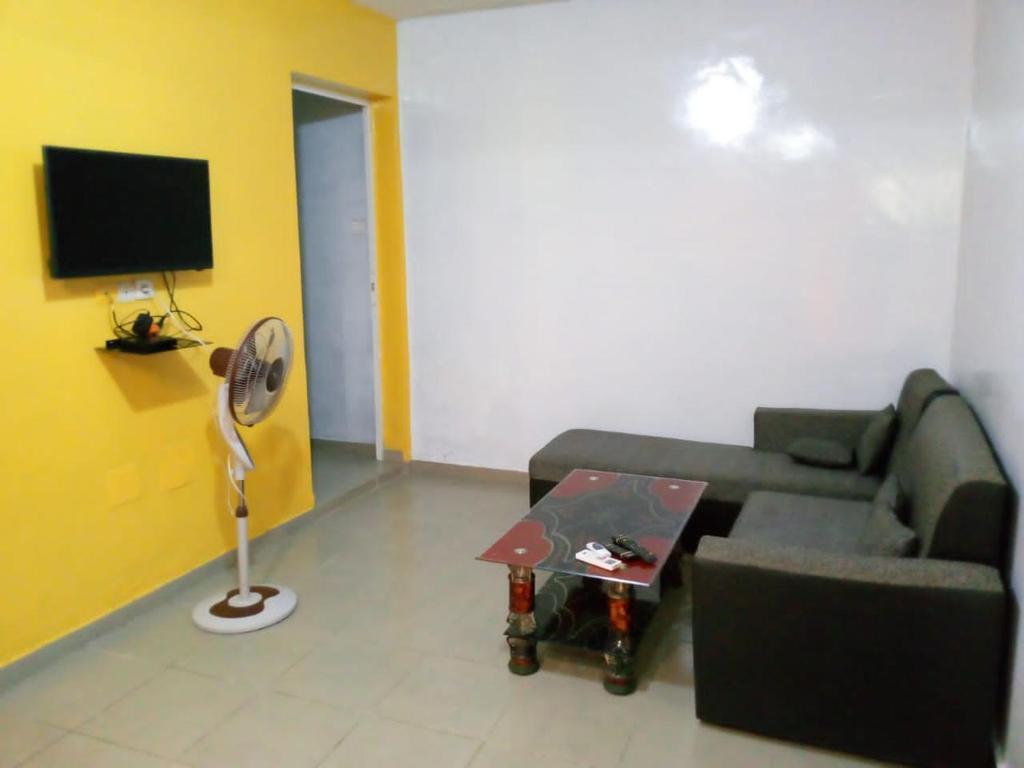 a living room with a couch and a fan at Appart F2 Lomé centre in Lomé