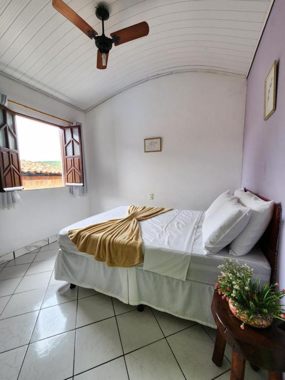 a bedroom with a bed and a ceiling fan at Pousada Velho Garimpo in Lençóis