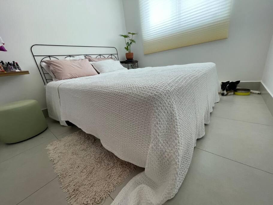 ein Schlafzimmer mit einem Bett mit einer weißen Bettdecke in der Unterkunft Incrível apê - Melhor Praia de Joao Pessoa in João Pessoa