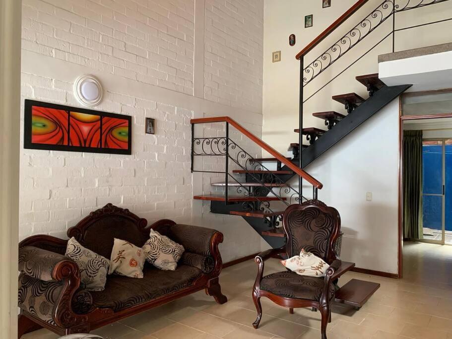 sala de estar con 2 sillas y escalera en Casa en Cartago Valle, en Cartago