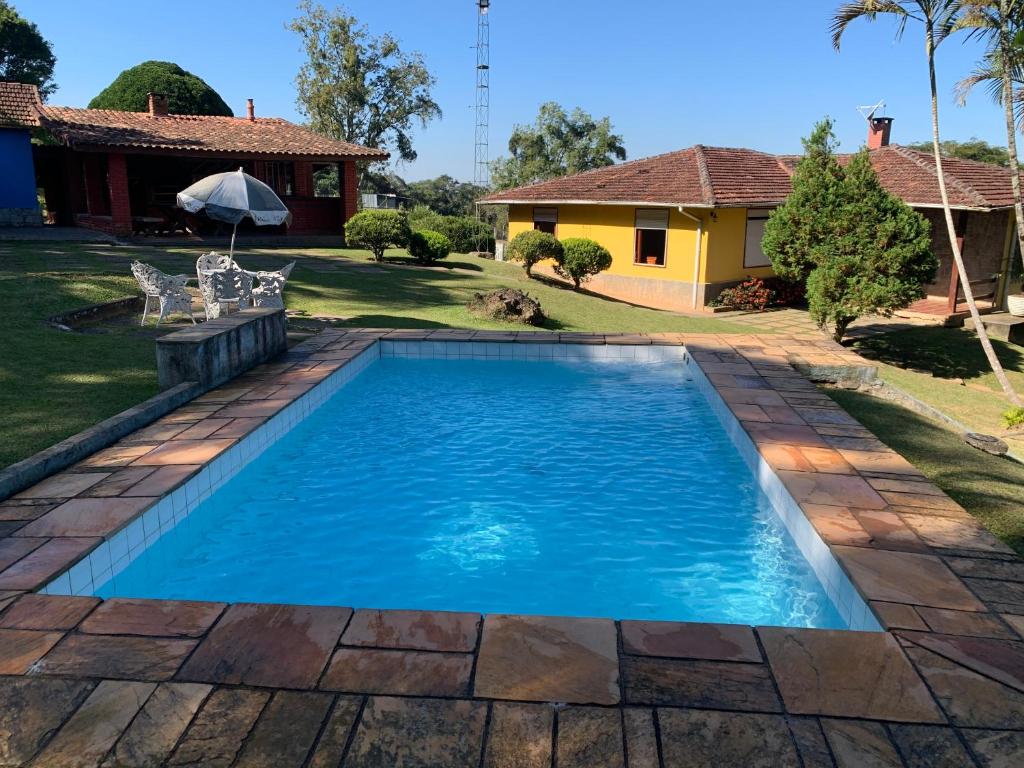 a swimming pool in the yard of a house at Sitio dos Sabias in Ibiúna