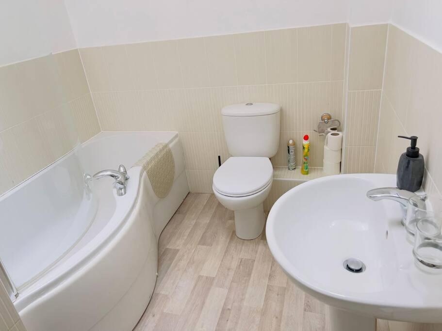 a bathroom with a tub and a toilet and a sink at 2 Bedroom Flat in Colchester in Colchester