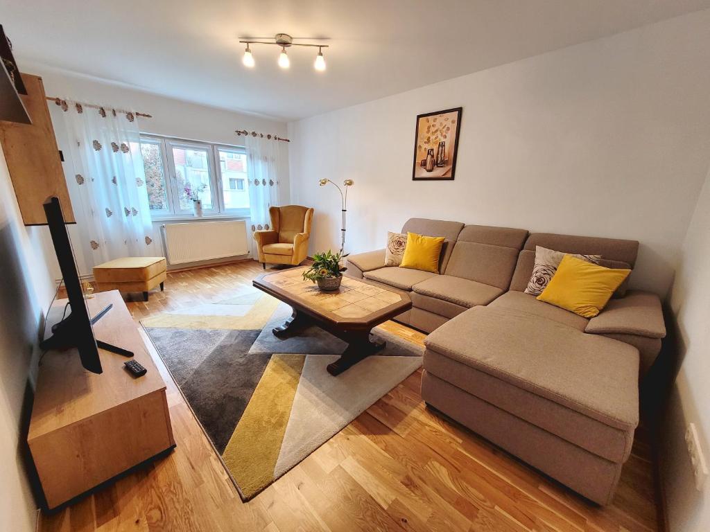 uma sala de estar com um sofá e uma mesa em Apartament Flora em Odorheiu Secuiesc