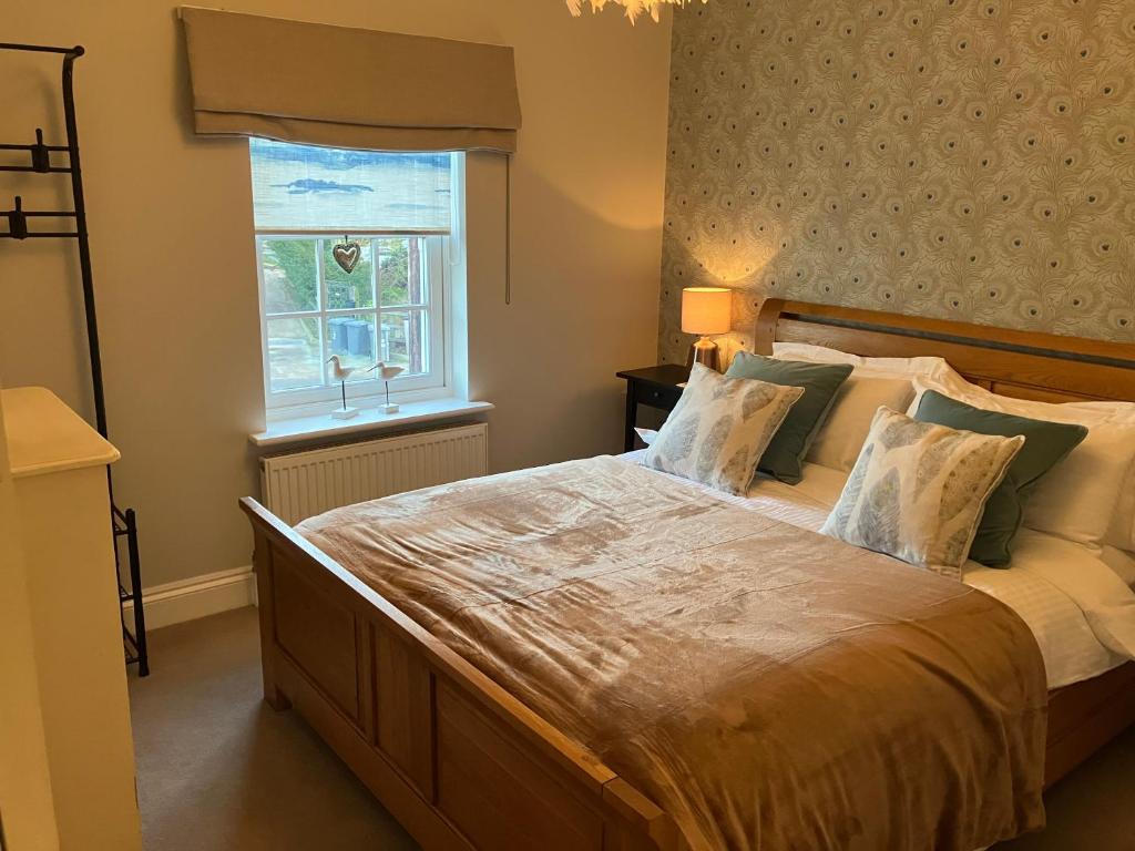 a bedroom with a large bed and a window at ROSEWOOD in Yoxford