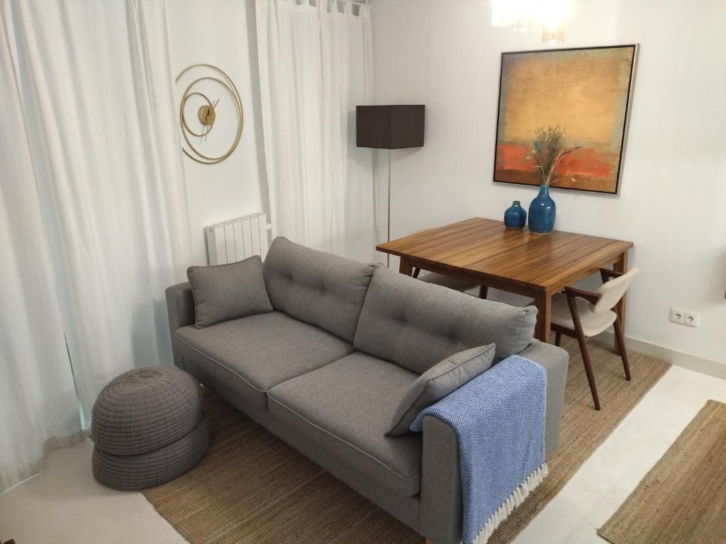 - un salon avec un canapé et une table dans l'établissement Cais das Pedras Pátio Apartment, à Porto