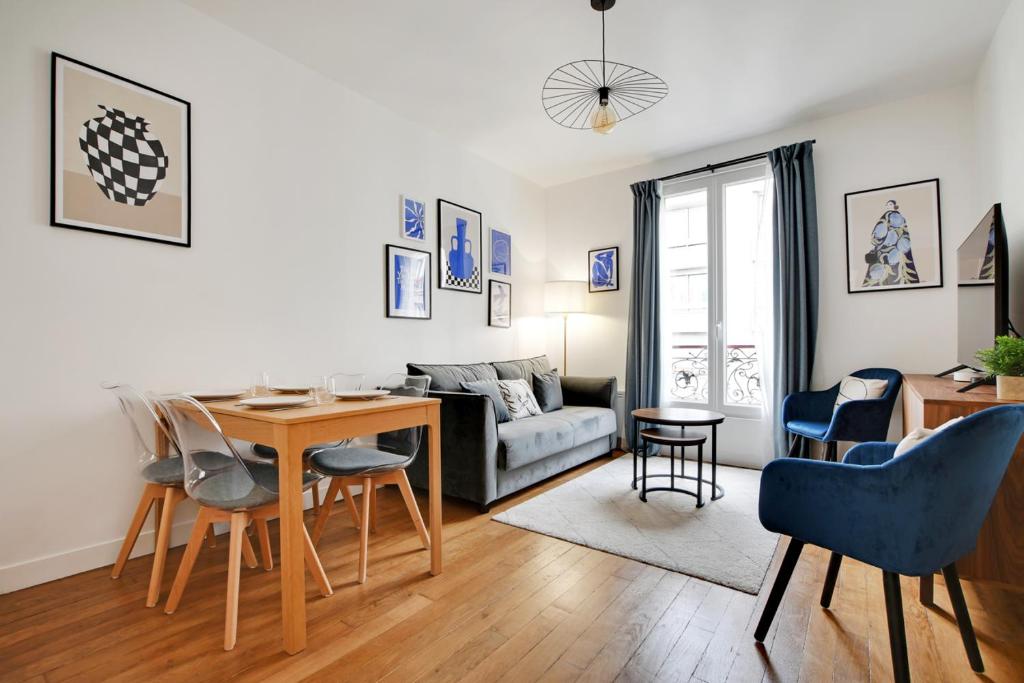 un salon avec une table et un canapé dans l'établissement Appartement spacieux -1BDR/4P -Le bas Montmartre, à Paris