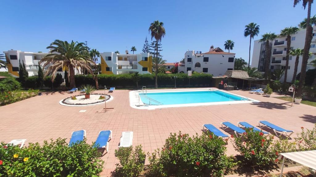 een zwembad in een resort met ligstoelen bij Holiday Apartment Alegranza in Playa del Inglés
