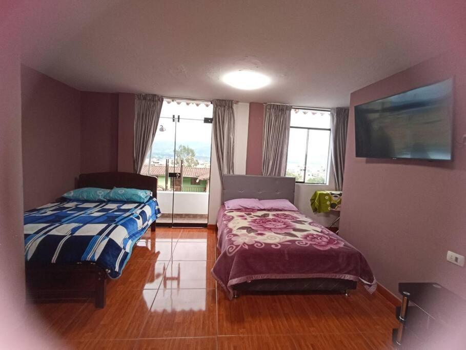 - une chambre avec 2 lits et une fenêtre dans l'établissement Habitación doble con balcón. bonita vista, à Cajamarca