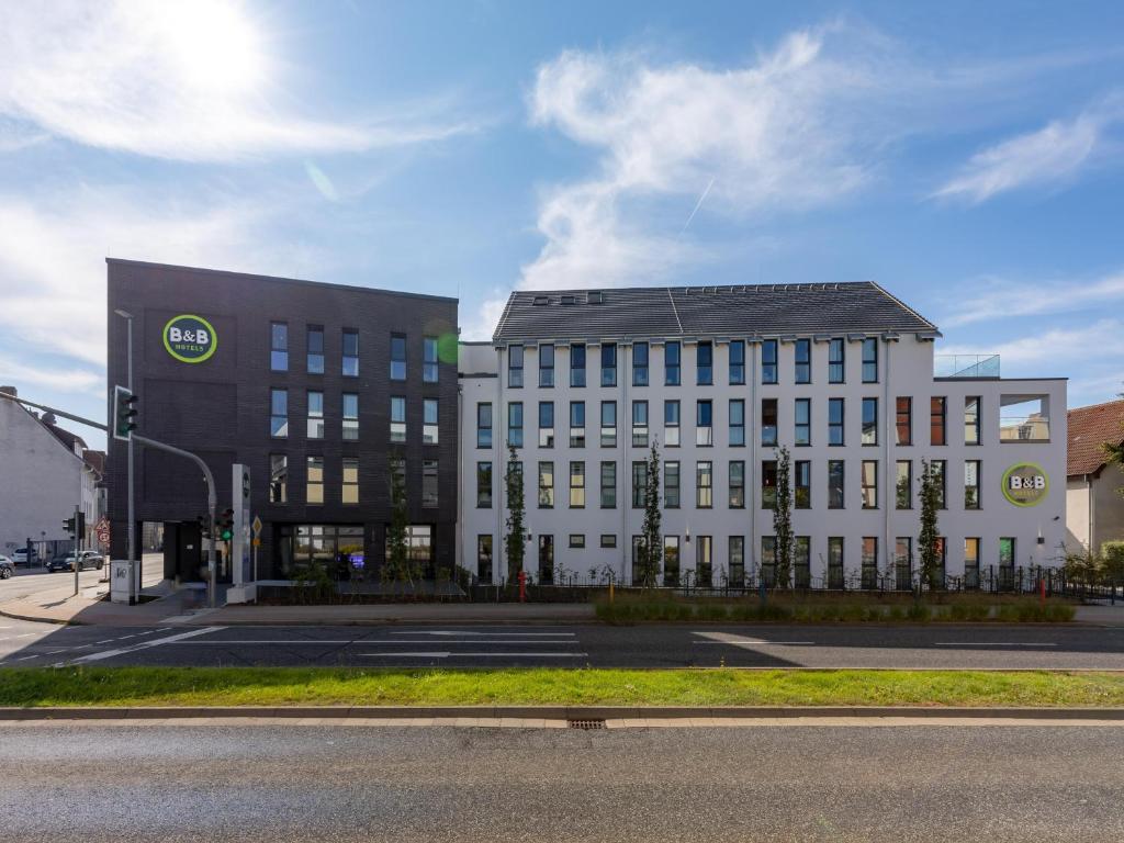 two large buildings on a city street with a road at B&B HOTEL Bad Hersfeld in Bad Hersfeld
