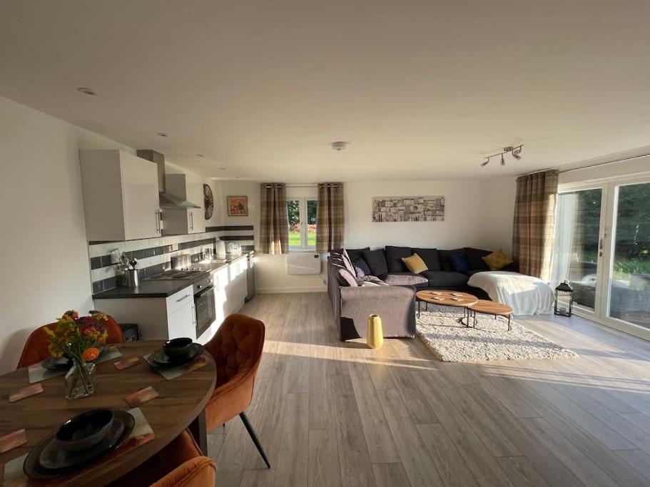een woonkamer en een keuken met een bank en een tafel bij Gorgeous modern furnished cabin in Steyning in Steyning