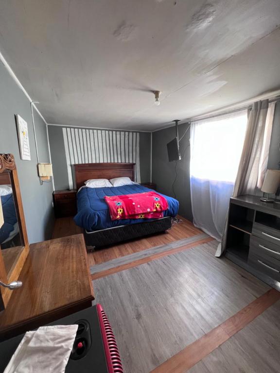 Un dormitorio con una cama y una mesa. en Casa capdeville en Puerto Williams