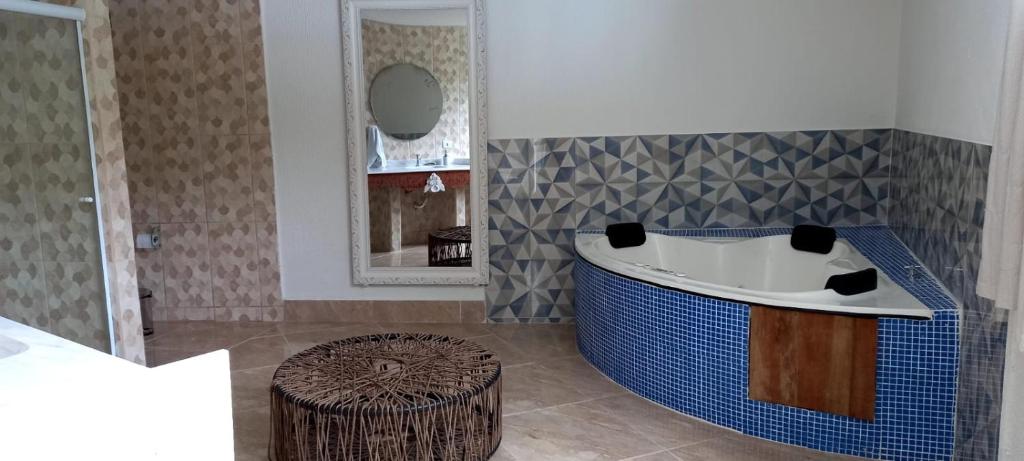 a bathroom with a tub and a mirror at Pousada restaurante recanto do Marimar in Paraty