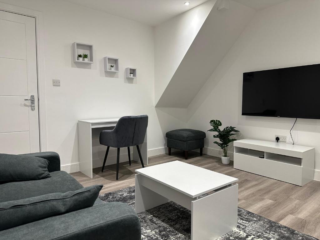 uma sala de estar com um sofá e uma televisão em Modern Apartment in Luton town Centre em Luton