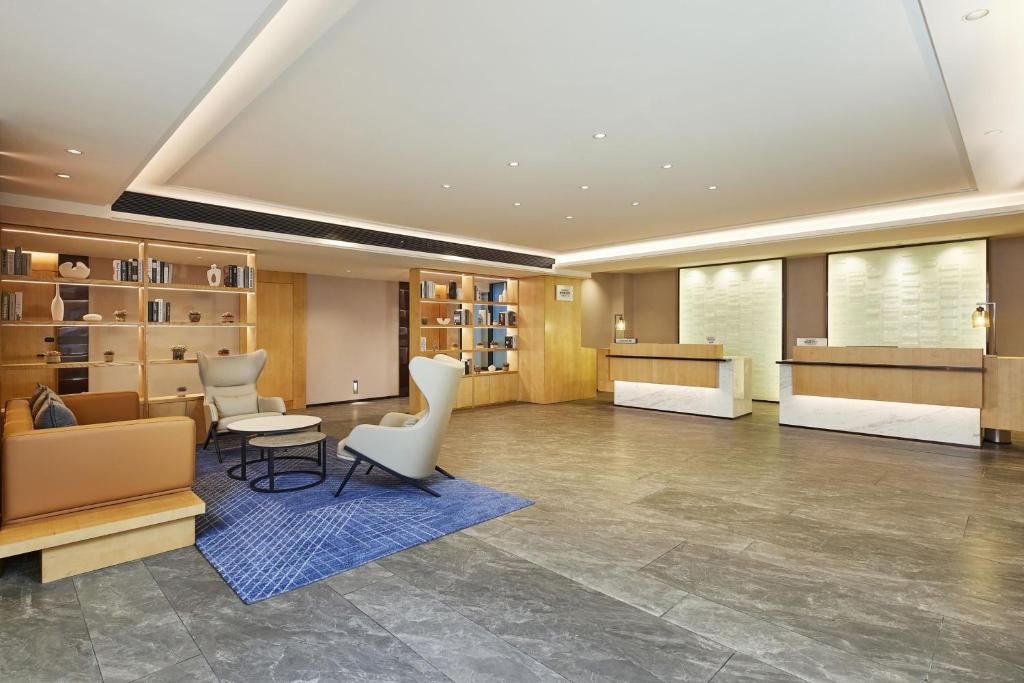 a lobby with a waiting area with chairs and a table at Fairfield by Marriott Changsha Tianxin in Changsha