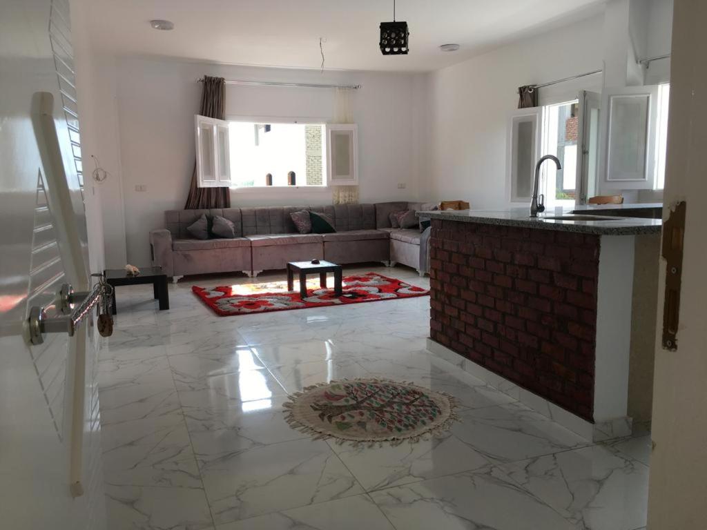 cocina y sala de estar con sofá y barra. en Muhammed Ali House en Luxor
